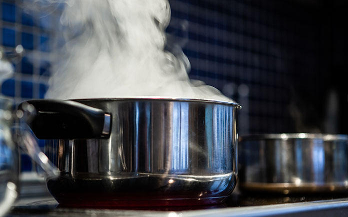 Closeup of steam rising from a stainless steel pot