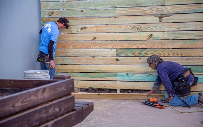 Two workers build a wooden stage and backdrop in Marianna, Florida