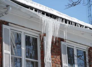 Ice dams pull down a gutter on a brick home