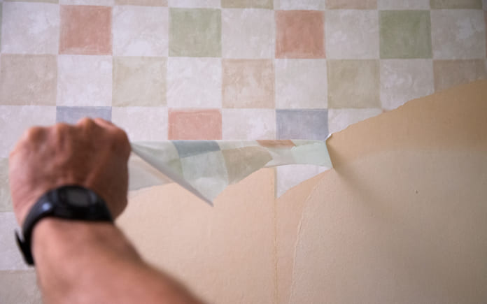 Removing checkered wallpaper from a wall.