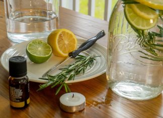 DIY mosquito repellant ingredients: lemon, lime, rosemary, oil, candle, water, mason jar