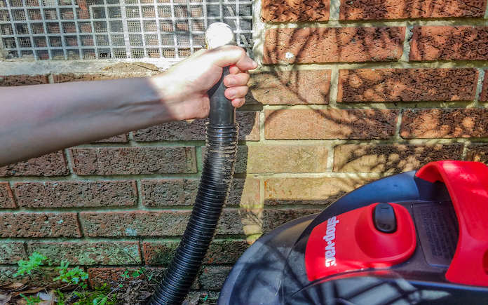 Shop vac vacuuming out an AC drain line during the home for home maintenance