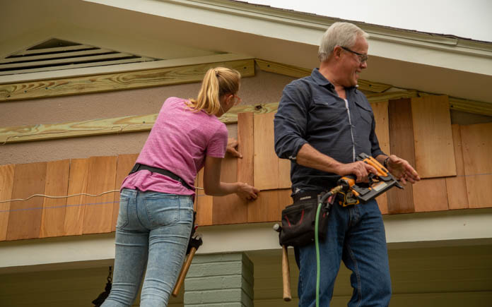 “Today’s Homeowner” hosts Danny Lipford and Chelsea Lipford Wolf install wood shakes over a gable. 