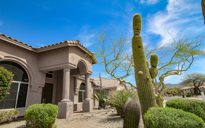A home in Arizona with large cacti in the front yard. 