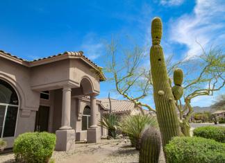 A home in Arizona with large cacti in the front yard.