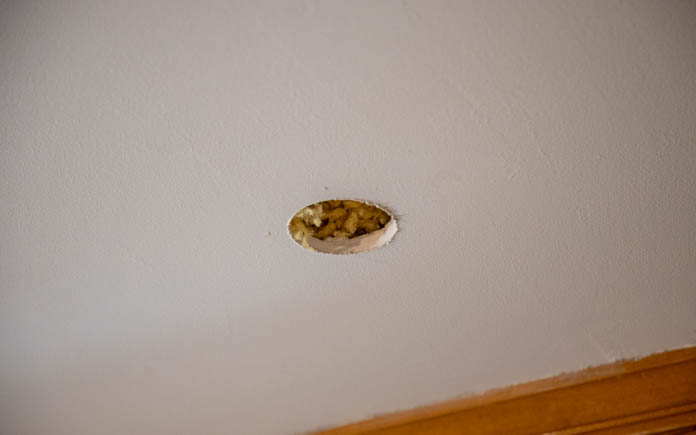 A hole in the drywall ceiling to install recessed lighting.