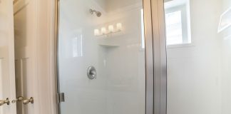 Fiberglass shower with glass paneling and stainless steel frames.