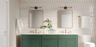 Newly remodeled bathroom with white tile walls, a green vanity with white countertops, gold finishings on the sink, mirrors, and lights, and white flooring and toilet