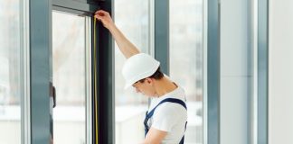 Worker installing a new window in construction gear