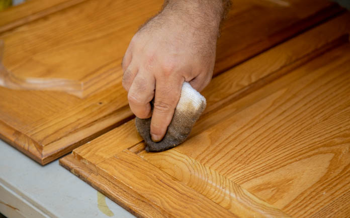 Homeowner Lloyd Meyers touching up the stain to his kitchen cabinets.