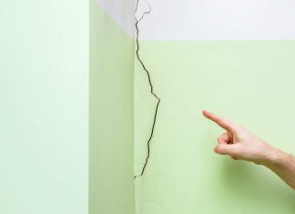 Finger pointing to cracked drywall
