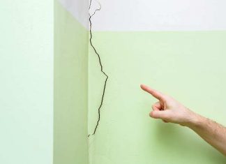 Finger pointing to cracked drywall
