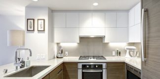 Modern kitchen with wood/white cabinets, white countertops, and stainless steel appliances