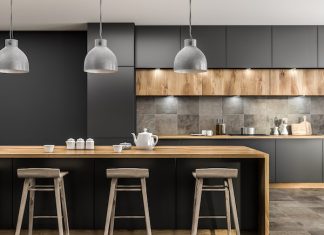 Modern kitchen interior with gray walls, tiled floor, gray countertops and wooden bar with stools.
