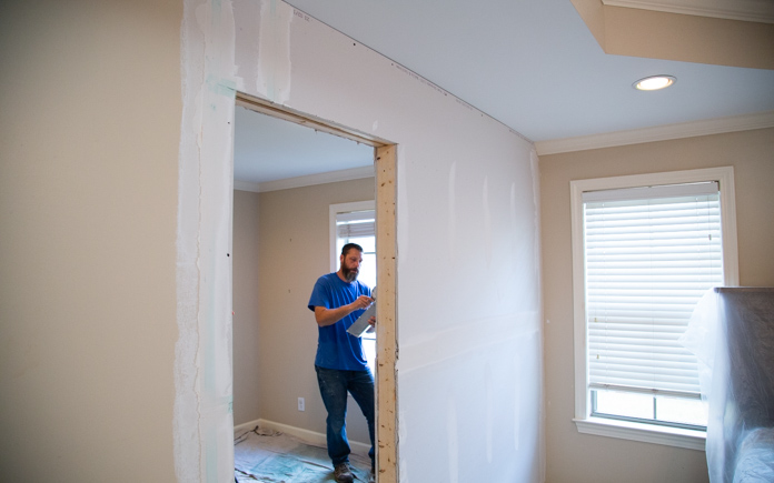 John from Danny Lipford Construction finishes drywall on a non load bearing wall.