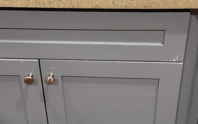 A lacquer painted kitchen cabinet with chips