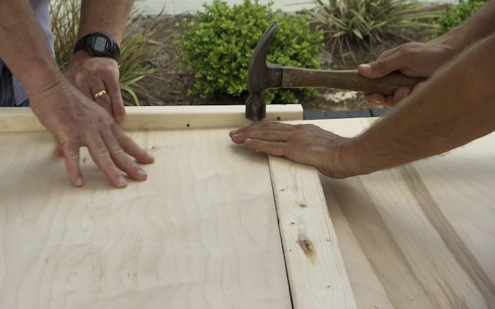 Hammering plywood into the frame of a daybed