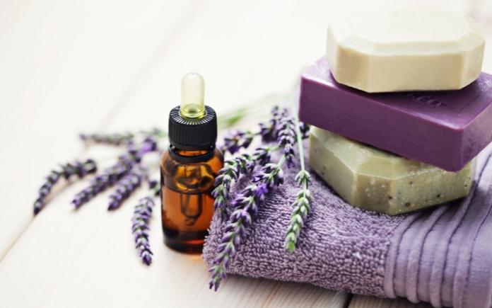Essential oil, lavender flowers, bars of soap on a towel