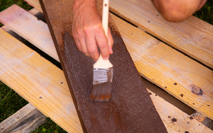Brush staining cedar wood plank