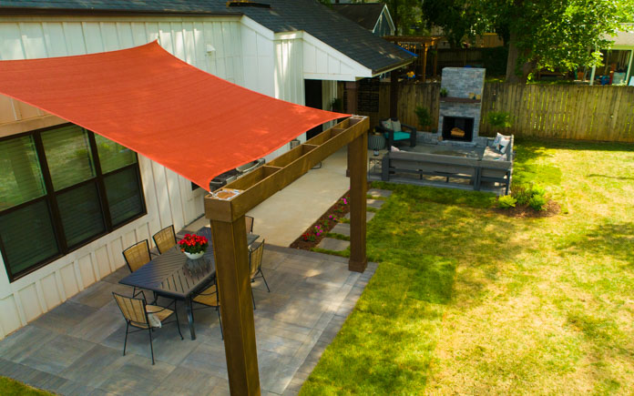 backyard with two paver patios and a shade sail