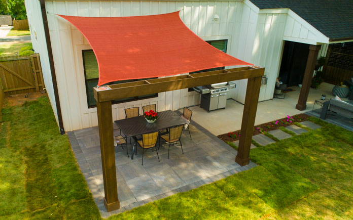 Shade sail over paver patio and outdoor dining table