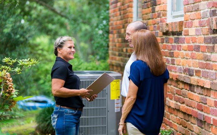 Couple speaks with a home air conditioner technician