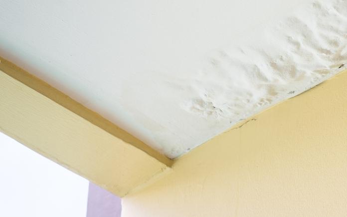 Water damaged ceiling with drywall wrinkles and ripples