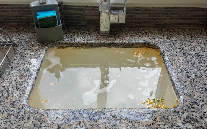 Clogged kitchen sink on a granite countertop