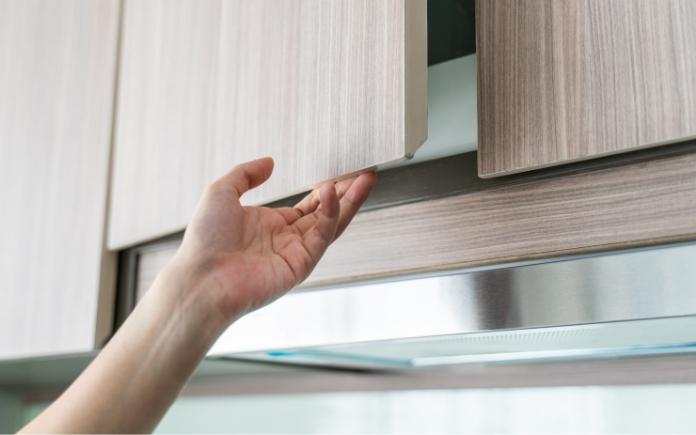 Hand opening a kitchen cabinet