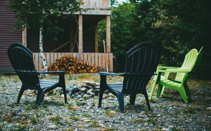 Black and green plastic outdoor furniture around a fire pit