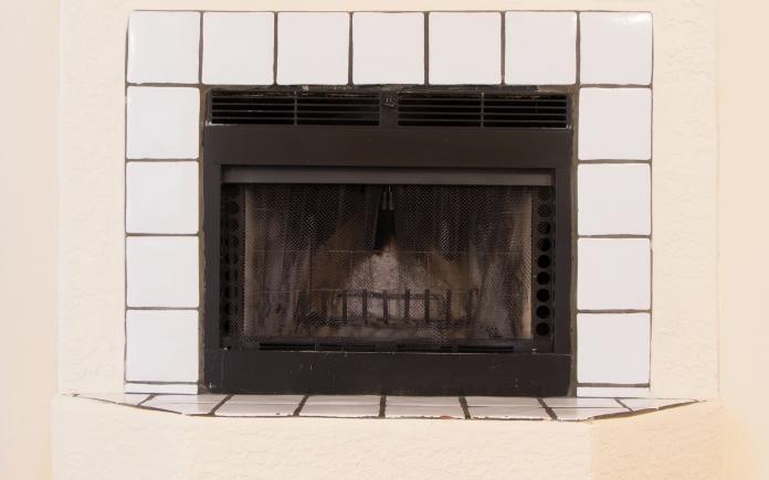 White tile fireplace with beige drywall