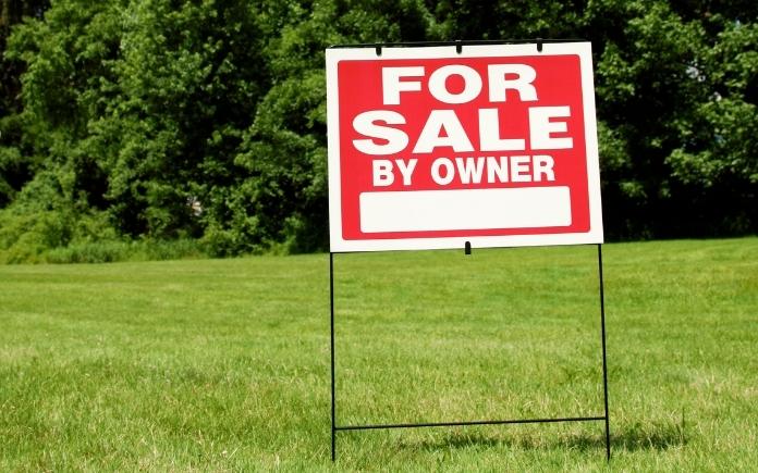 For sale by owner of sign on green grass