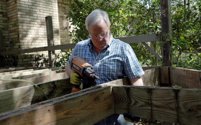 Today's Homeowner TV host Danny Lipford drills into a deck joist 