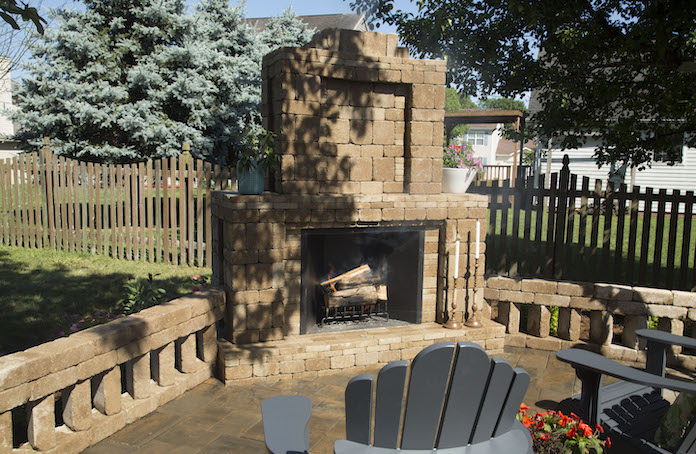 The paver outdoor fireplace is made with brown Rumblestone pavers from Pavestone