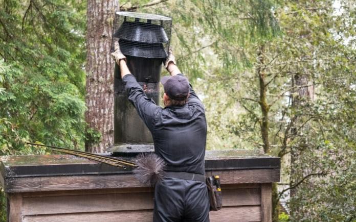 chimney sweep cleaning and inspecting a chimney