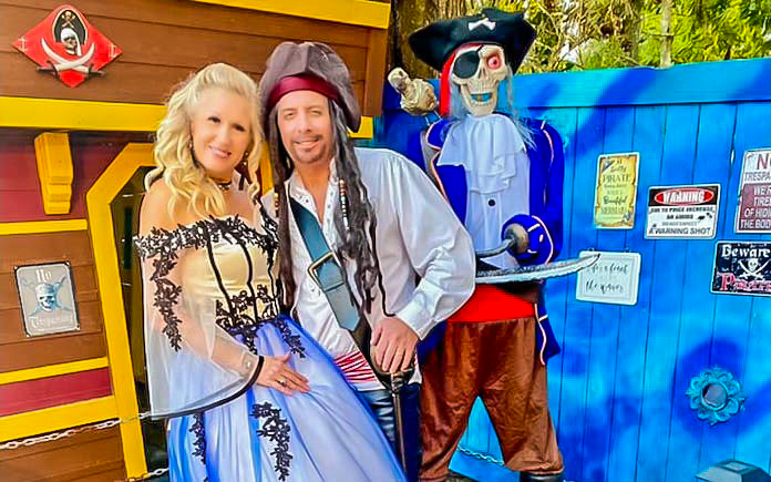 Jeff and Debbie Headrick post in front of their Pirate Ship Playhouse on Halloween.