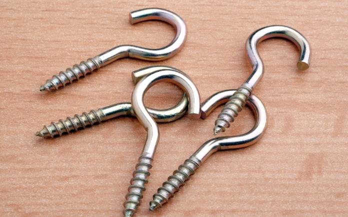 Screw hooks on a wooden background