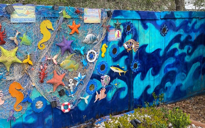 Fence painted with underwater blue waves with starfish and fish decor