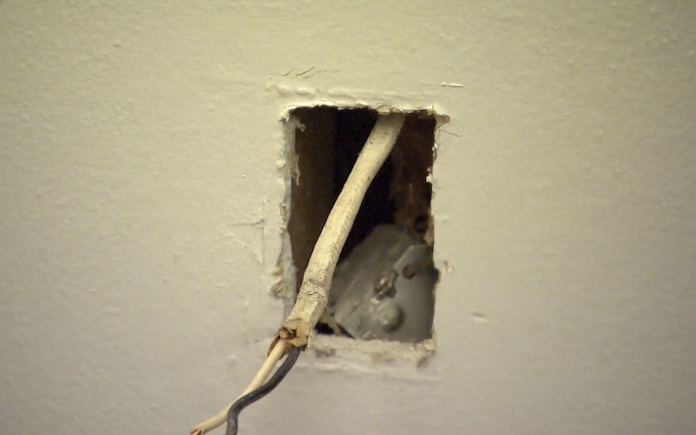 Hole in wall with electrical wires coming out