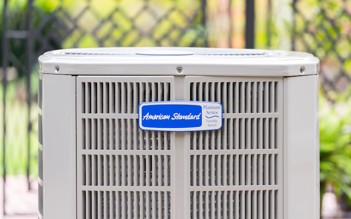 Close up on logo of American Standard Platinum 20 Heat Pump / Air Conditioner placed outside