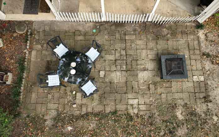 Overhead view of a badly damaged and aged paver patio