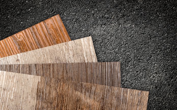 PVC vinyl floor samples on a dark background of asphalt texture