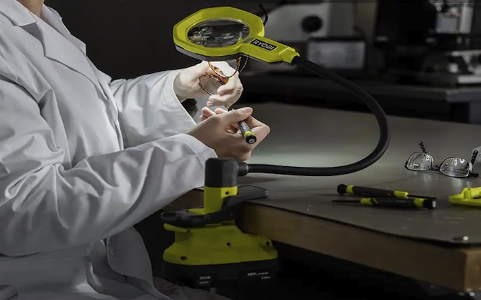 Ryobi ONE+ 18V LED Magnifying Glass with Light clamped to the side of a workspace