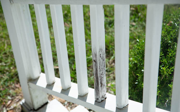 Front porch handrail with a rotten wood spindle