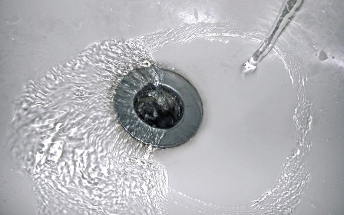 Tap water pouring over a drain