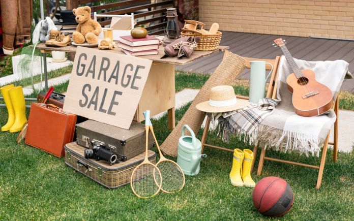 Various items placed on a table and chairs outside a home for a garage sale