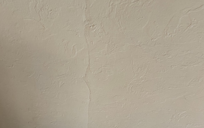 Crack in beige plaster wall