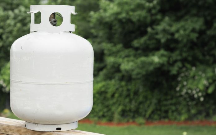Propane tank against wooded background