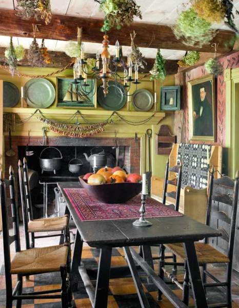 The tavern room, which serves as the main entrance, is also the breakfast room. Clusters of drying herbs hang over antique furnishings.