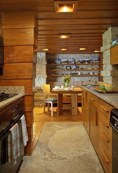 the-view-to-the-dining-room-through-the-galley-kitchen-new-cabinets-in-cypress-reproduce-the-design-of-the-plywood-originals-durable-new-materials-include-flagstone-flooring